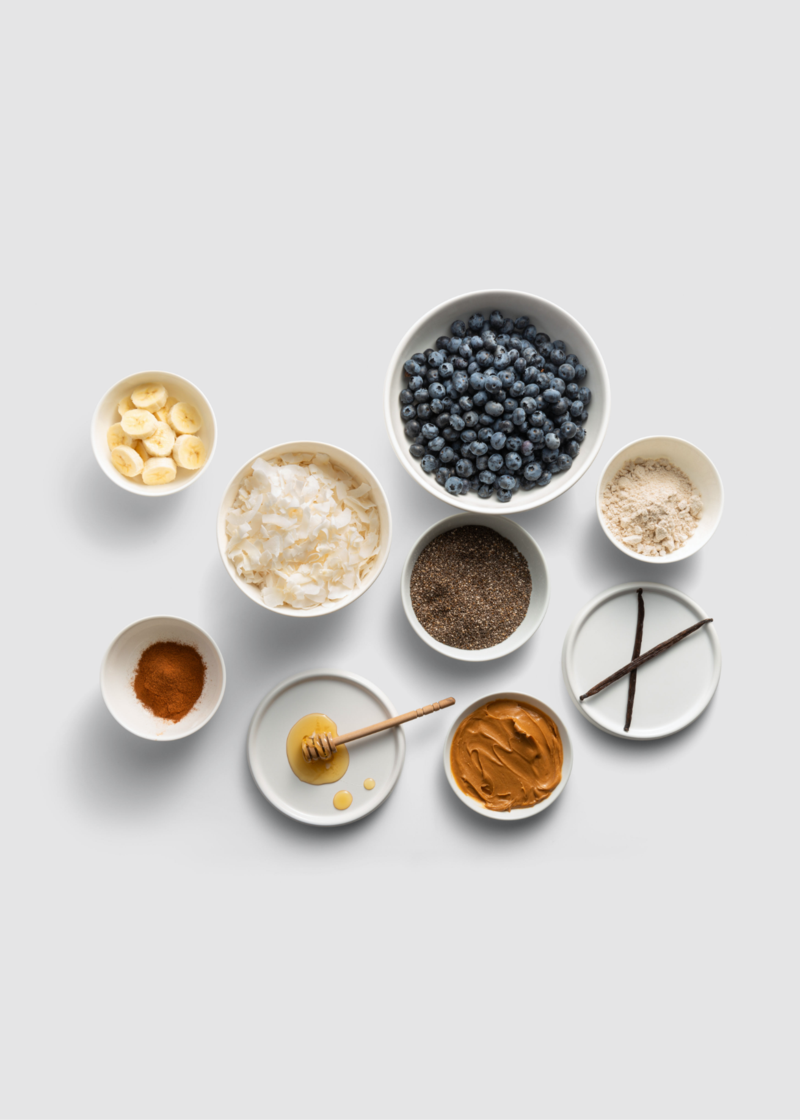 superfoods in bowls including blueberries, bananas, honey, peanut butter and coconut